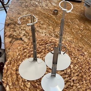 Three white metal doll stands